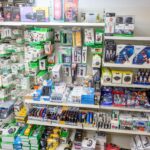 Regalwand in einem Fachgeschäft mit verschiedenen verpackten Elektronik- und Handy-Zubehörartikeln