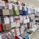 Regal mit verschiedenen Gardinen, Vorhängen und Gardinenzubehör in einem Discounter.
