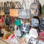 Regalwand mit vielen verschiedenen Handtaschen und Rucksäcken in einem Geschäft