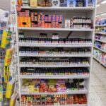 Regal mit verschiedenen ätherischen Ölen, Räucherstäbchen und Duftkerzen in einem Geschäft.