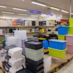 Stapel von bunten Plastikboxen und Transportbehältern auf Paletten in einem Lager