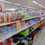 Regal in einem Discountladen mit verschiedenen Plastikdosen, Boxen und Küchenutensilien.