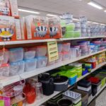 Regal mit Plastikdosen, Schüsseln und Metall-Küchensets