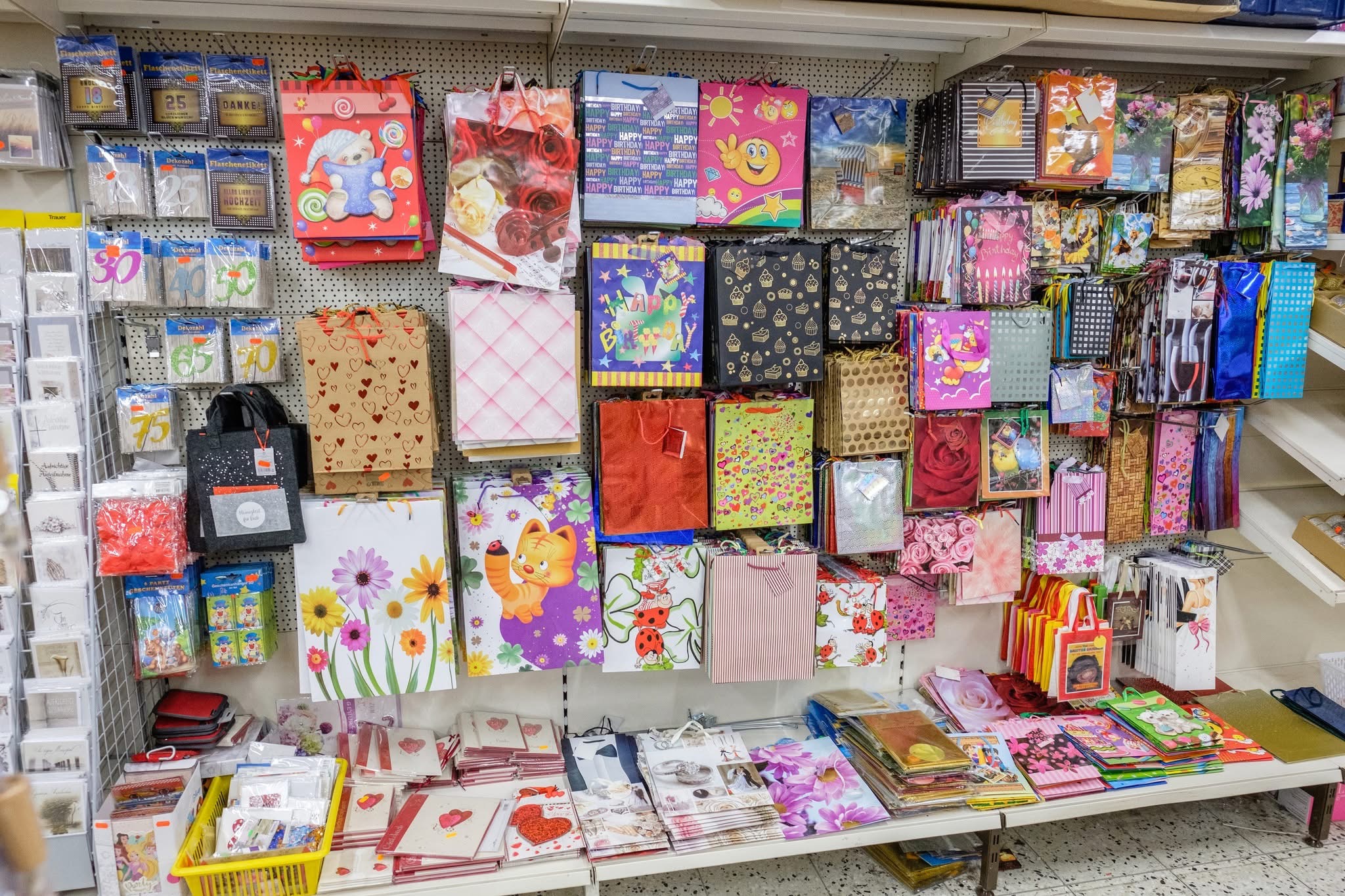 Regalwand mit vielen bunten Geschenktüten und Grußkarten