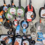 Regalwand mit hängenden Pfannen, Töpfen und Backformen in einem Haushaltswarenladen