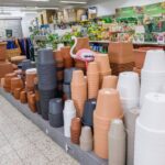 Sortiment von gestapelten Blumentöpfen in Terrakotta, Grau, Beige und Weiß in einem Gartencenter.