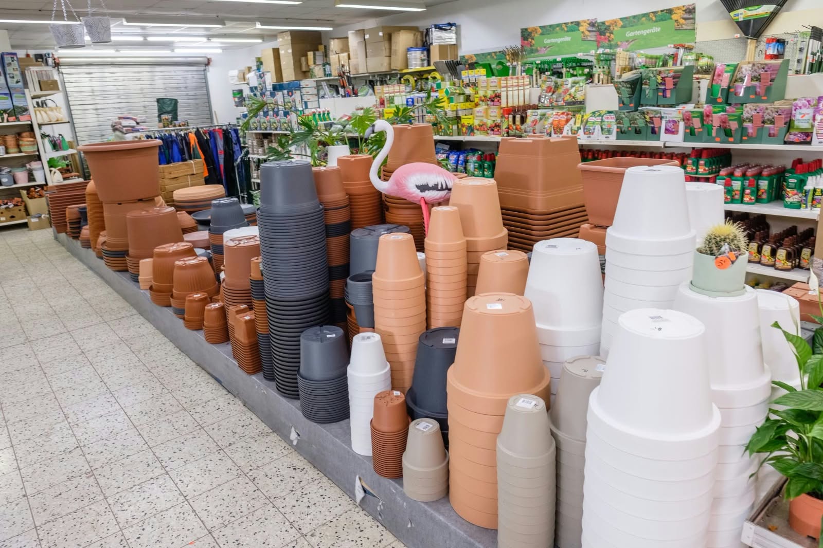 Sortiment von gestapelten Blumentöpfen in Terrakotta, Grau, Beige und Weiß in einem Gartencenter.
