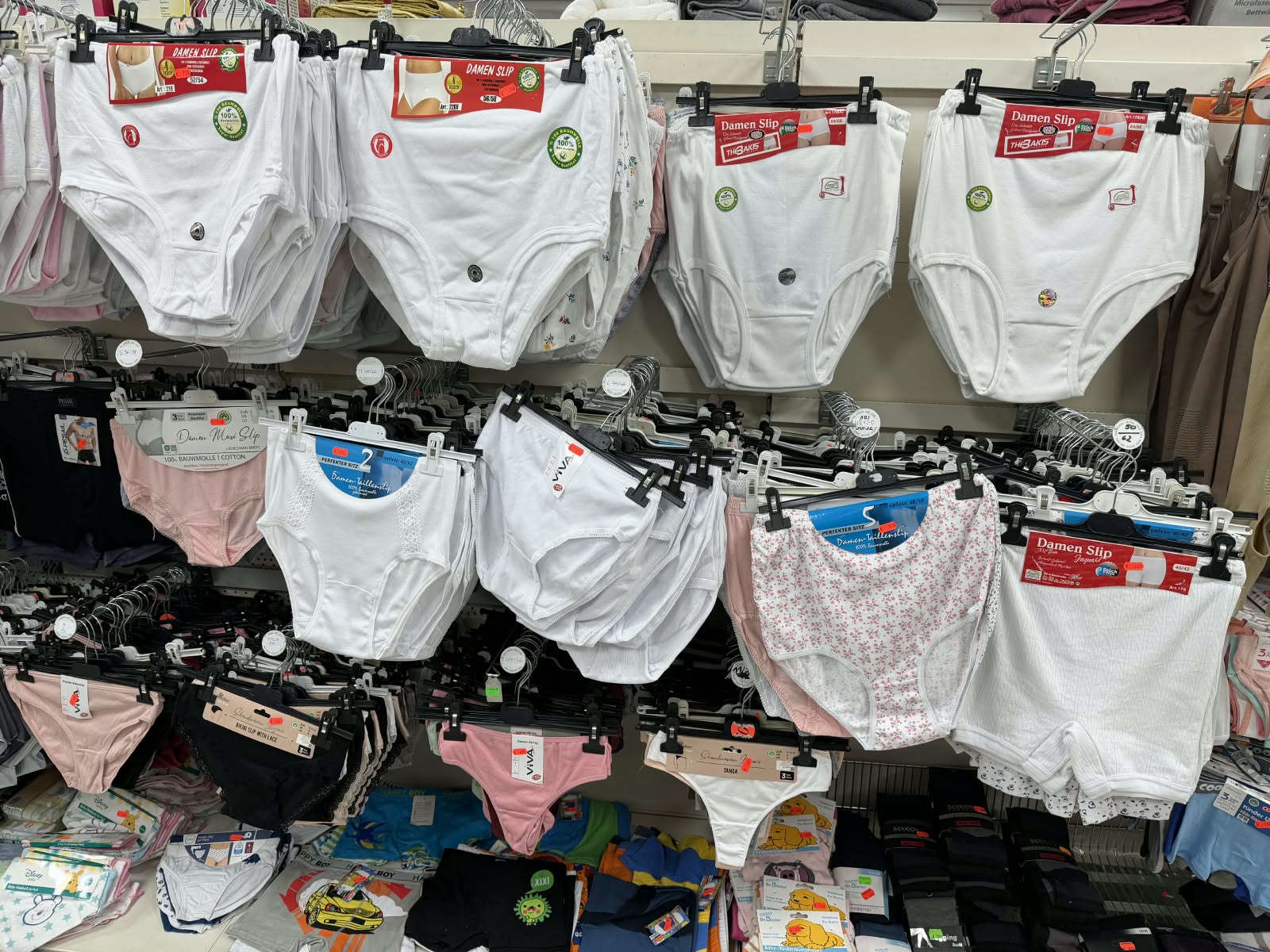 Regal mit verschiedenen Damen-Slips und Unterhosen in Weiß und Pastellfarben
