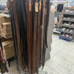 Verschiedene Lederhosen-Gürtel in Schwarz und Braun auf einem Ständer in einem Geschäft