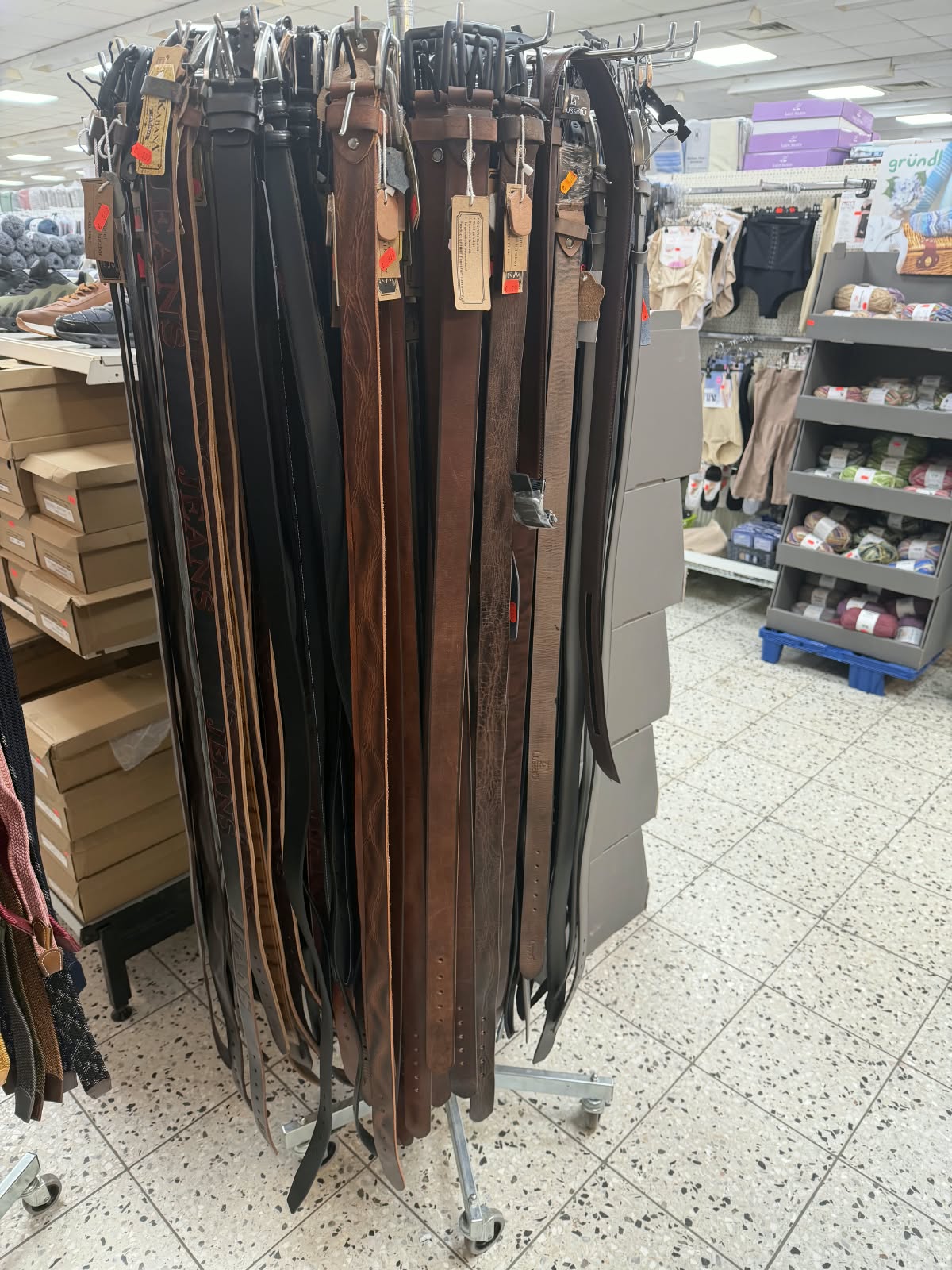 Verschiedene Lederhosen-Gürtel in Schwarz und Braun auf einem Ständer in einem Geschäft